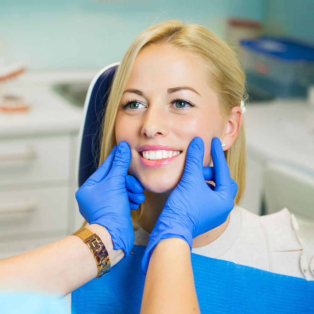 A woman receiving dental care with a smile on her face.